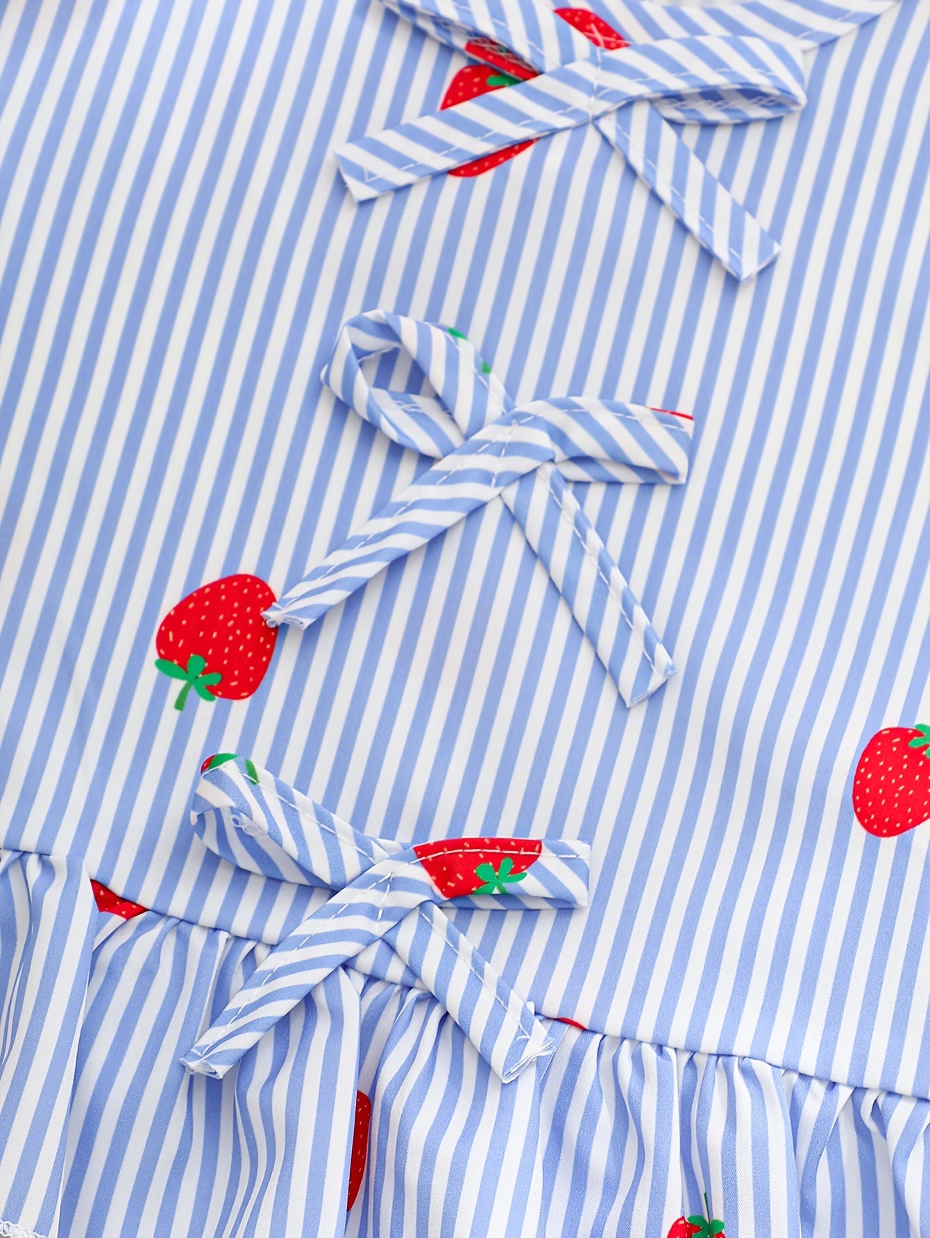 A Two-Piece Set. A Tank Top And Shorts Outfit Featuring Strawberry Prints, Striped Patterns, Bow Decorations, And a Ruffled Hem Design. This Is a Casual Summer Outfit for Girls. It Makes a Great Gift for Girls' Clothing. Suitable for Outdoor Wear